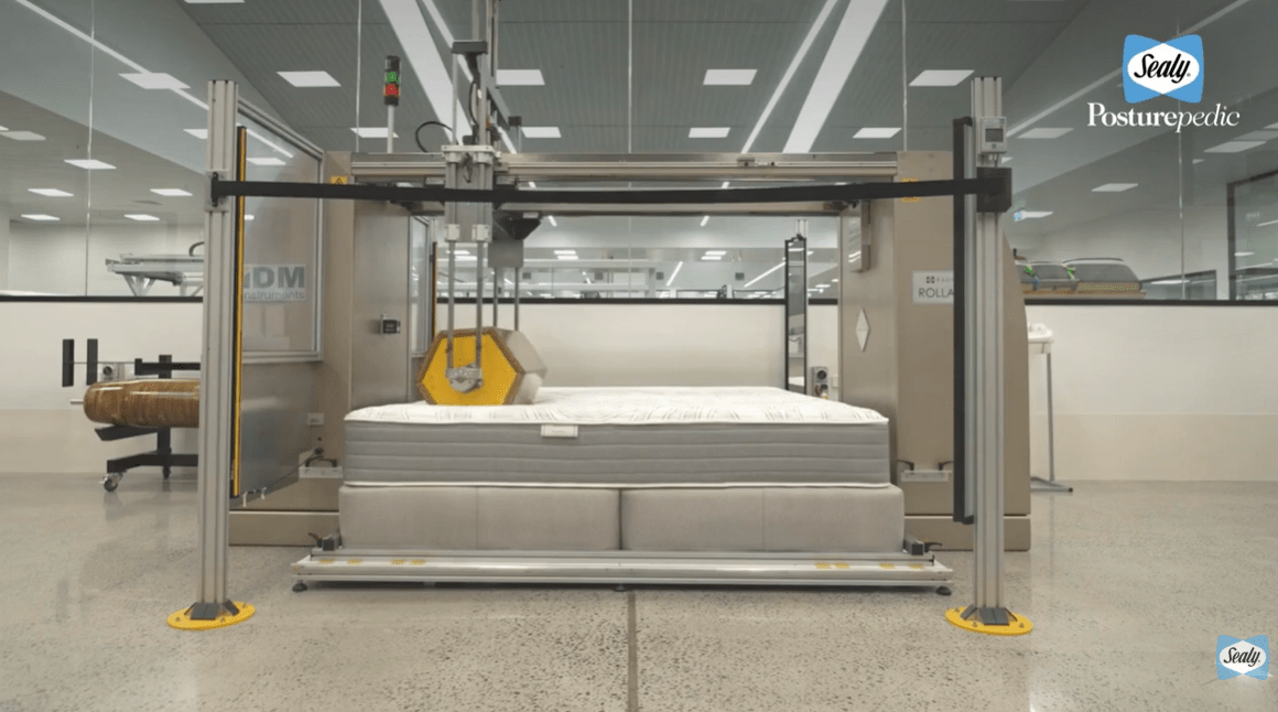 Why Hotel Mattresses Feel So Comfortable: How to Recreate the Experience at Home 3 Sealy Rollator Test in progress at a NATA-accredited mattress durability lab