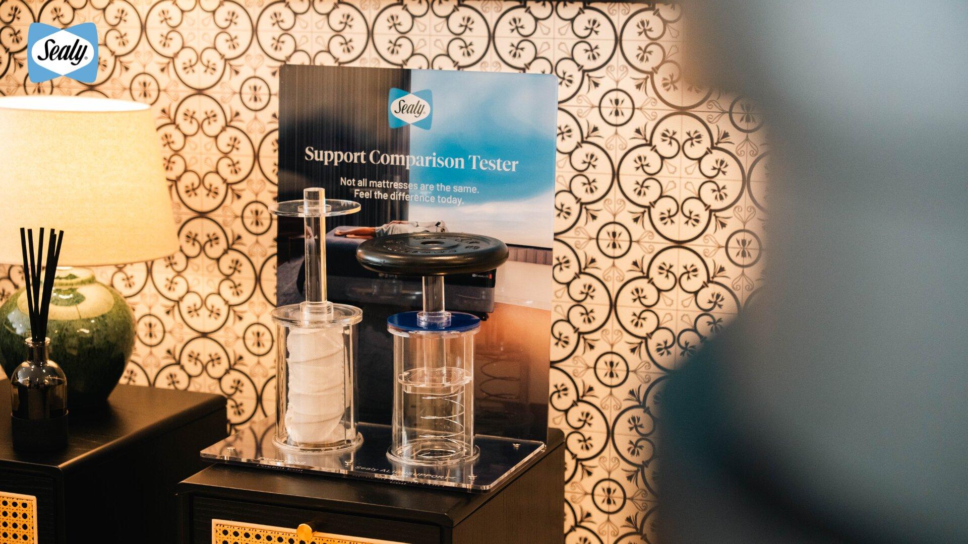 Discover Sealy Sleep Boutique Penang: A New Destination for First-Class Sleep 9 Support Comparison Tester at the Penang boutique, weighing a pocket coil against a Sealy AlignSUPPORT™ coil
